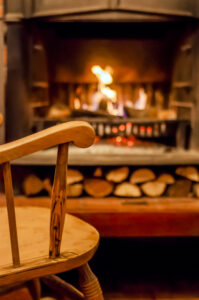 Home comfort. Rocking chair near the fireplace. Photo of interio