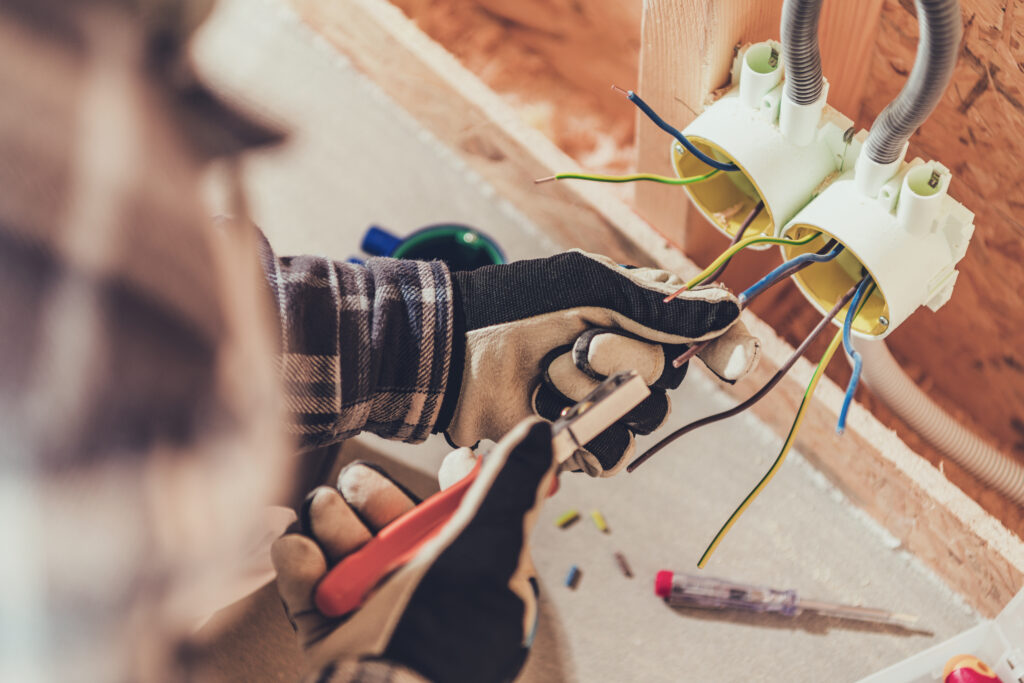 Électricien travaillant avec des câbles électriques sur un chantier.