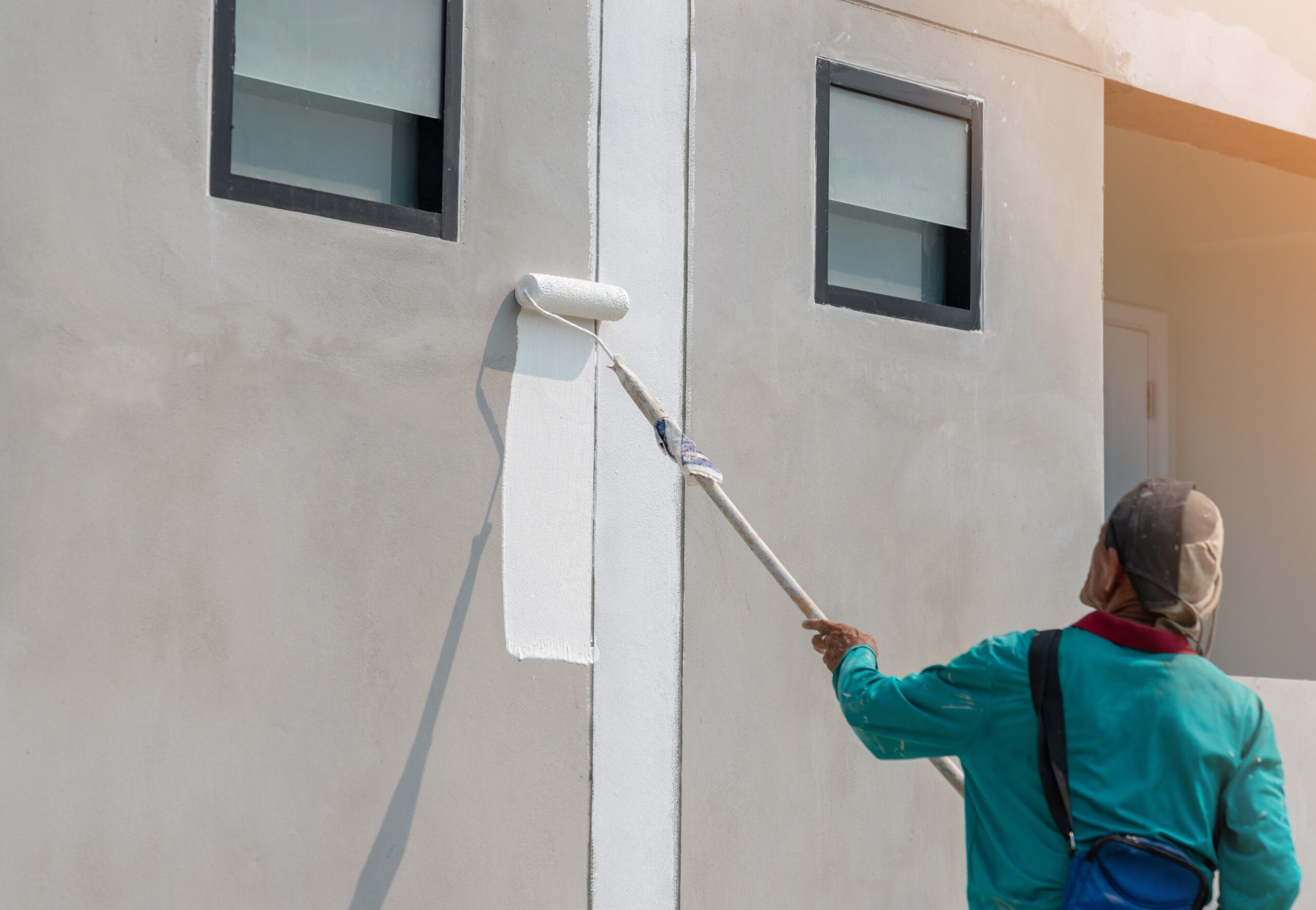 Façadier appliquant un enduit ou réalisant des travaux de rénovation sur la façade d'une maison.