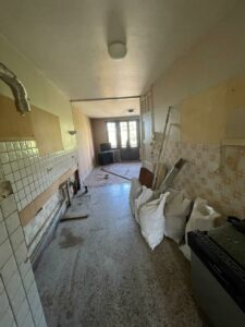 Travaux en cours dans la cuisine d’un appartement à Thonon, murs mis à nu et ancien carrelage déposé.