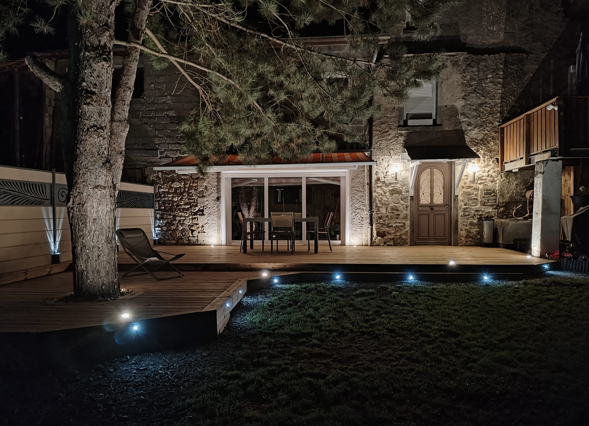 Terrasse en bois illuminée avec spots LED intégrés de nuit.