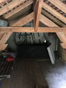 Grenier brut avant rénovation à Thonon avec charpente en bois et murs en pierre.