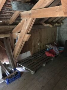 Combles anciens à Thonon avant rénovation avec charpente brute et espace en désordre.
