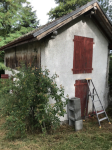 Maison ancienne à Thonon avant rénovation avec façade défraîchie et volets en bois rouge.