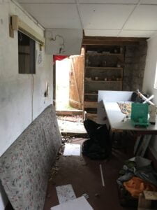 Intérieur d’une maison avant rénovation à Thonon, avec désordre et murs abîmés.