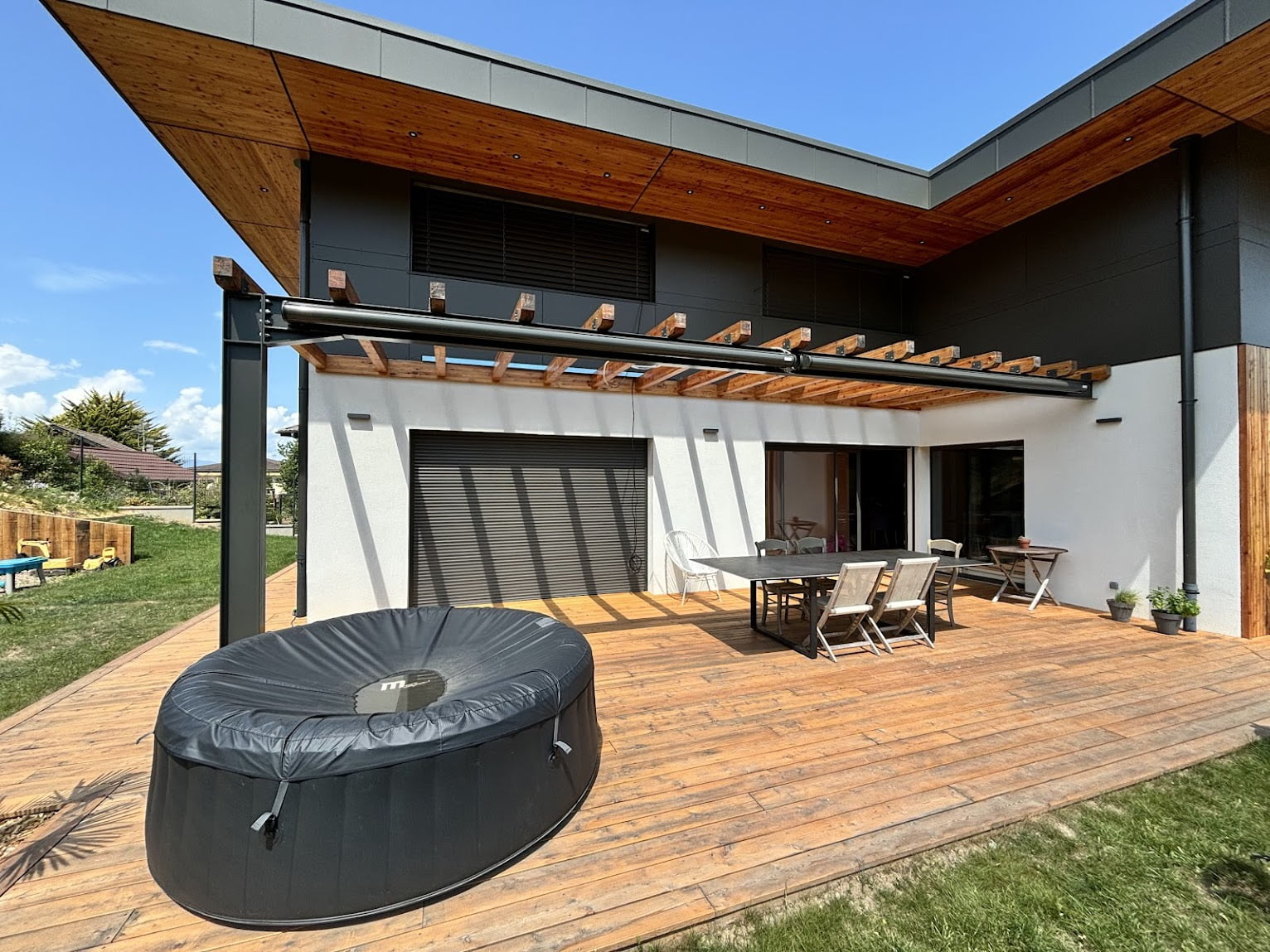 Terrasse en bois avec pergola et coin repas extérieur à Bons-en-Chablais.