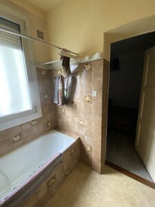 Ancienne salle de bains à Thonon avec baignoire et carrelage marron avant rénovation.