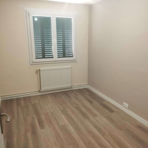 Chambre rénovée à Thonon avec parquet et peinture moderne.
