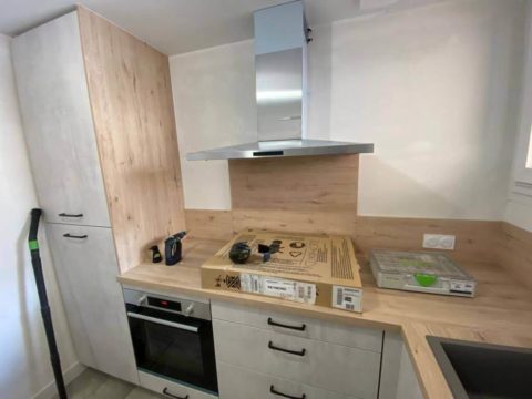 Travaux de rénovation d’une cuisine à Thonon avec meubles modernes et plan de travail en bois clair.