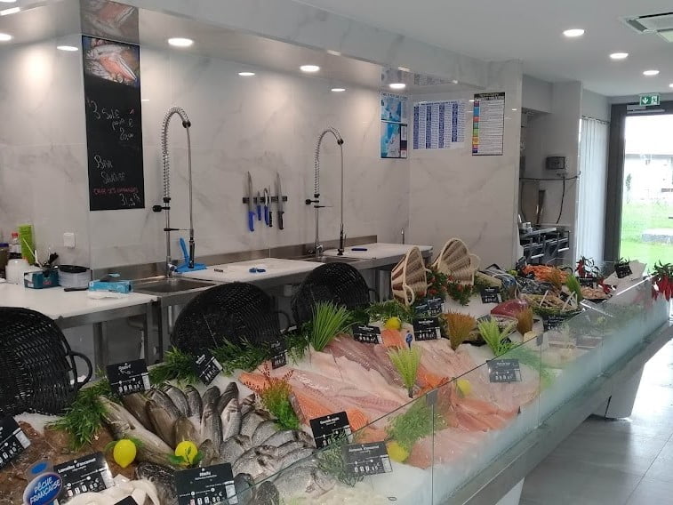 Comptoir rempli de produits frais dans une vitrine après aménagement poissonnerie Bons-en-Chablais.