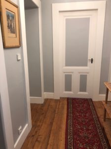Couloir rénové avec parquet en bois et murs peints dans une maison à Évian.