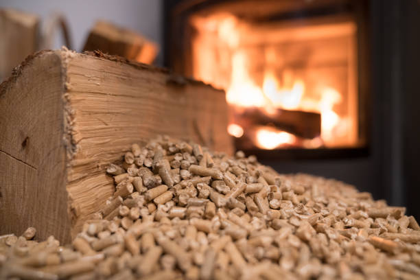 Granulés de bois devant un poêle allumé, système de chauffage écologique