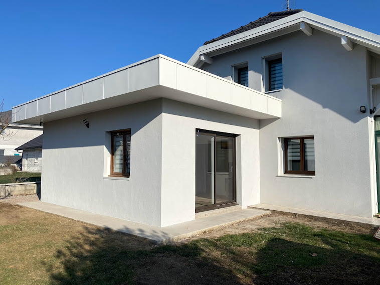 Extension de maison moderne avec enduit blanc et toit plat