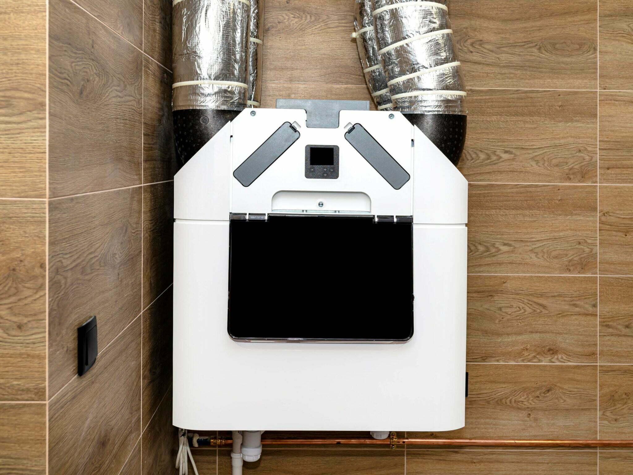 Système de VMC double flux installé dans une maison avec conduits d’aération isolés.