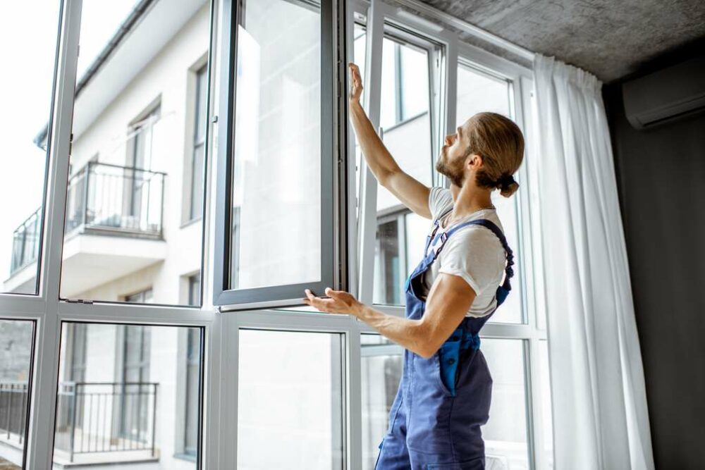 Artisan installant une fenêtre à double vitrage dans un appartement