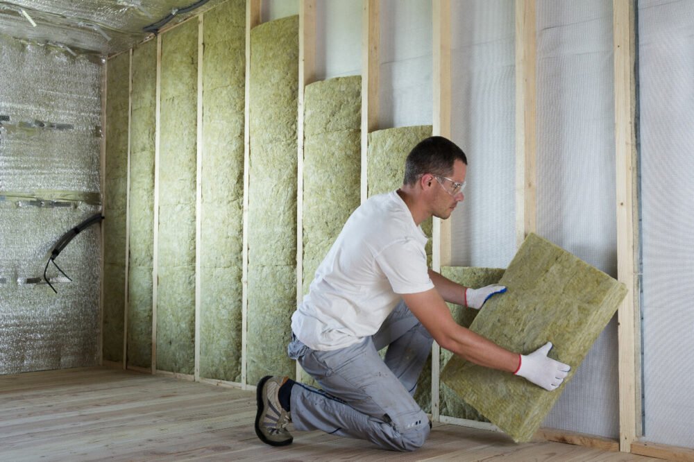 Pose de panneaux isolants en laine de roche sur une cloison en rénovation