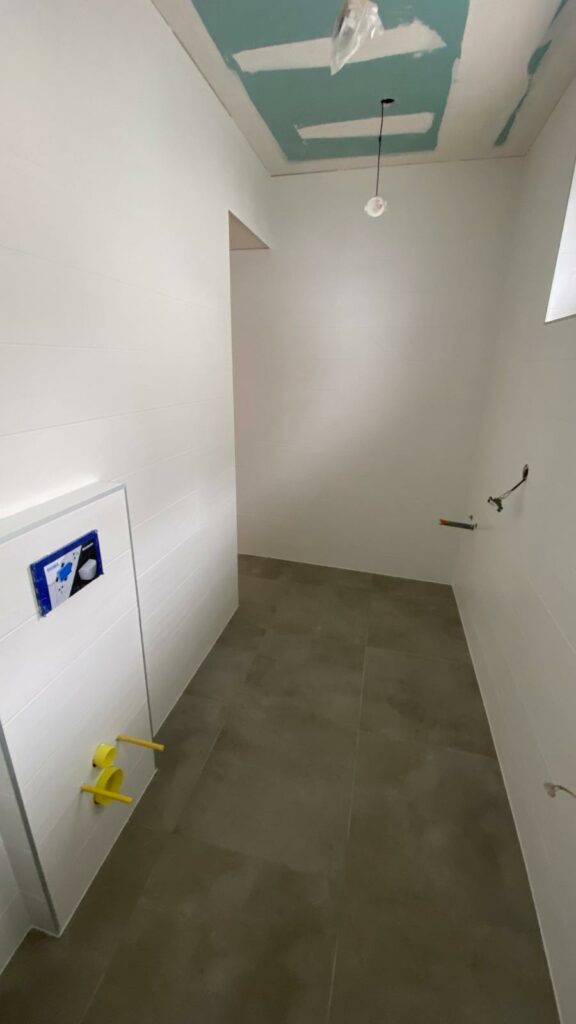 Salle de bains en cours de rénovation à Évian avec plafond et murs blancs en préparation