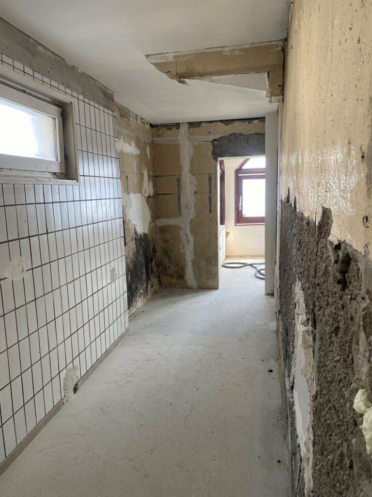 Salle de bains vétuste avec murs abîmés et carrelage ancien avant rénovation à Évian
