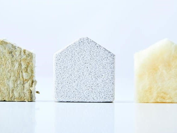 Trois matériaux isolants en forme de maison : laine minérale, polystyrène et mousse isolante