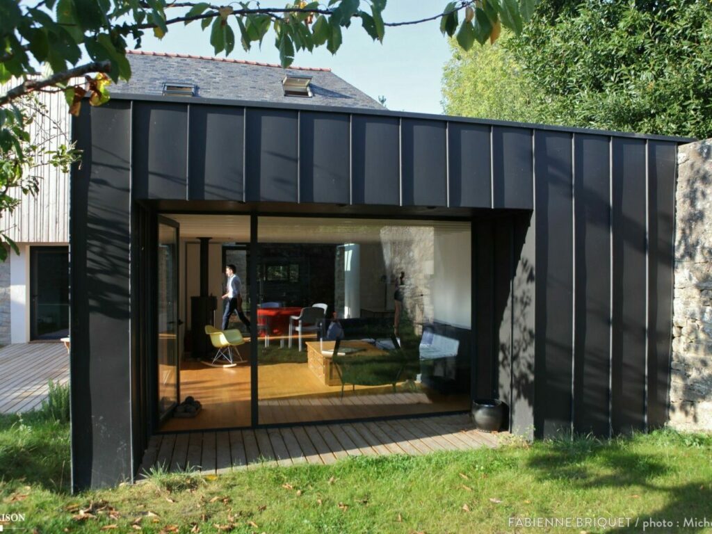 Extension maison Evian moderne en métal noir avec grandes baies vitrées.