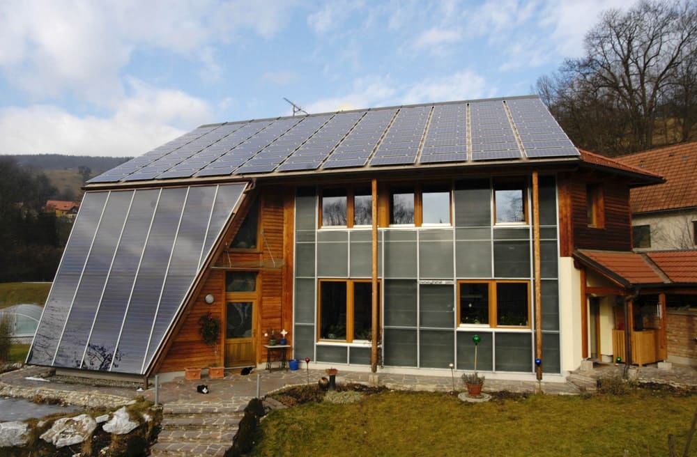 Maison passive à Evian équipée de panneaux photovoltaïques et de capteurs solaires inclinés pour maximiser les apports énergétiques.