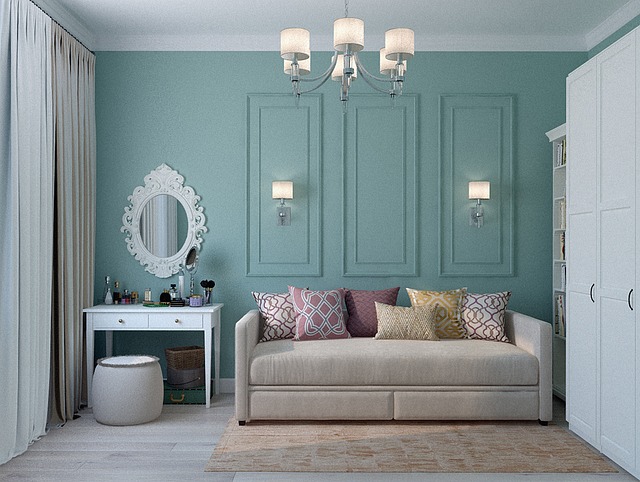 Pièce élégante aux murs vert-bleu avec moulures et décoration blanche