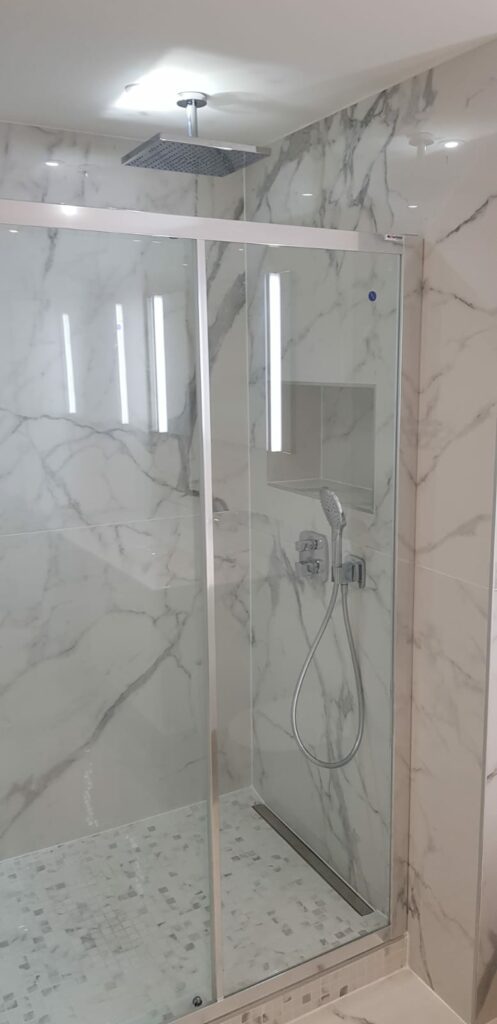 Douche à l’italienne avec parois vitrées et carrelage effet marbre blanc à Annemasse.