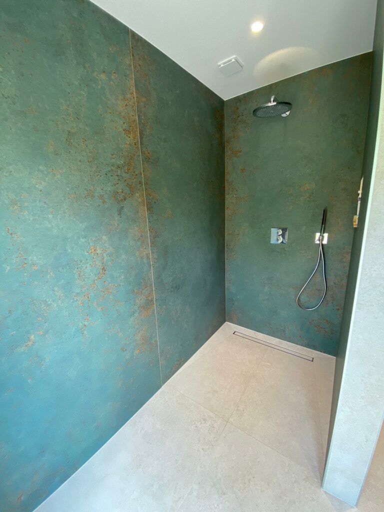 Douche spacieuse en carrelage vert minéral grand format.
