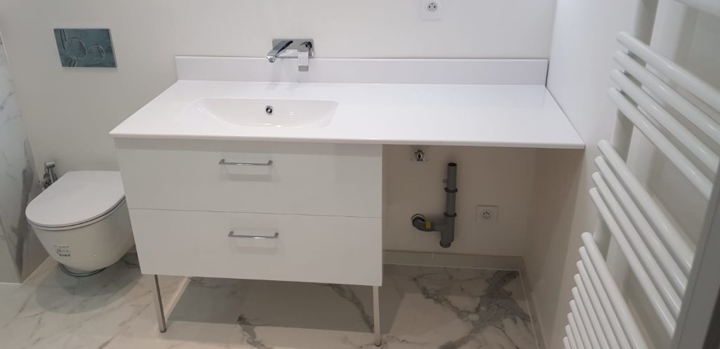 Meuble vasque blanc suspendu avec espace pour machine à laver dans salle de bain à Annemasse.