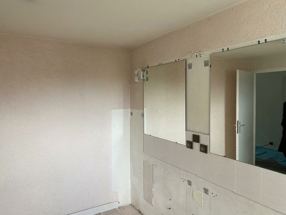 Mur de salle de bain vide avant rénovation à Bons-en-Chablais