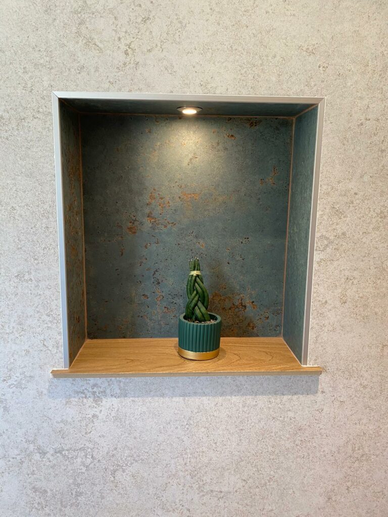 Niche murale décorative avec éclairage LED et fond en carrelage effet rouille.