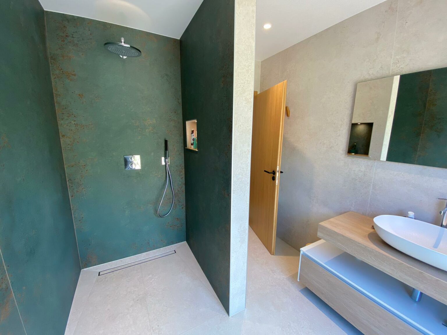 Salle de bain moderne avec murs en carrelage grand format vert et beige.