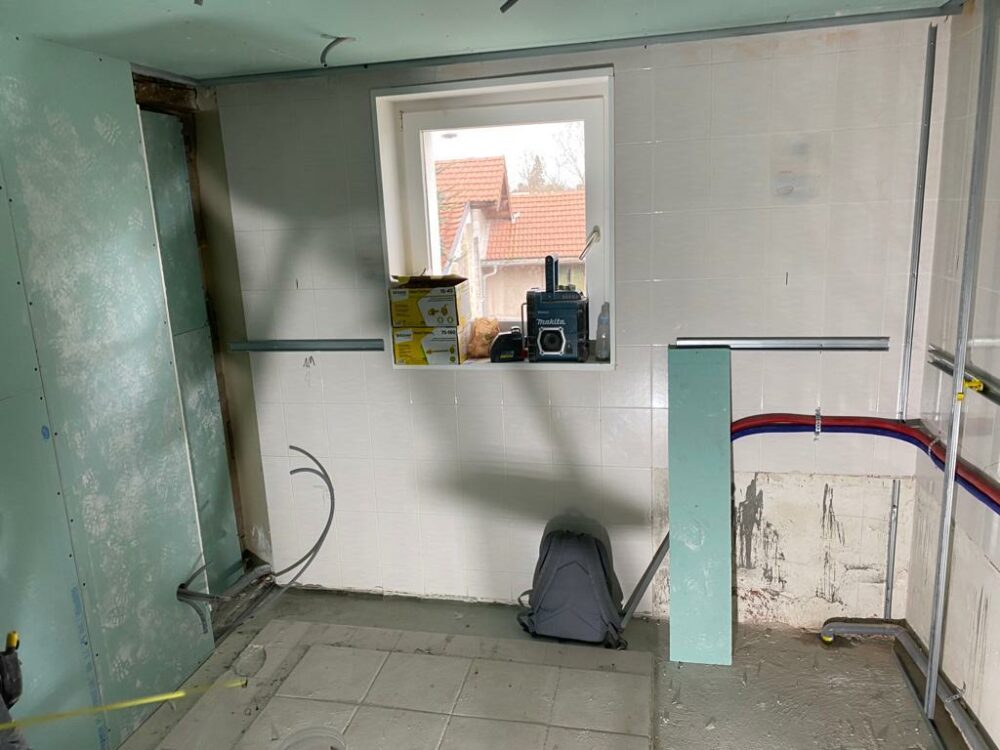 Travaux préparatoires avec raccordements de plomberie apparents dans salle de bain