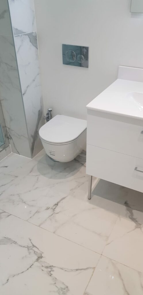 WC suspendu design avec carrelage mural et sol effet marbre à Annemasse.