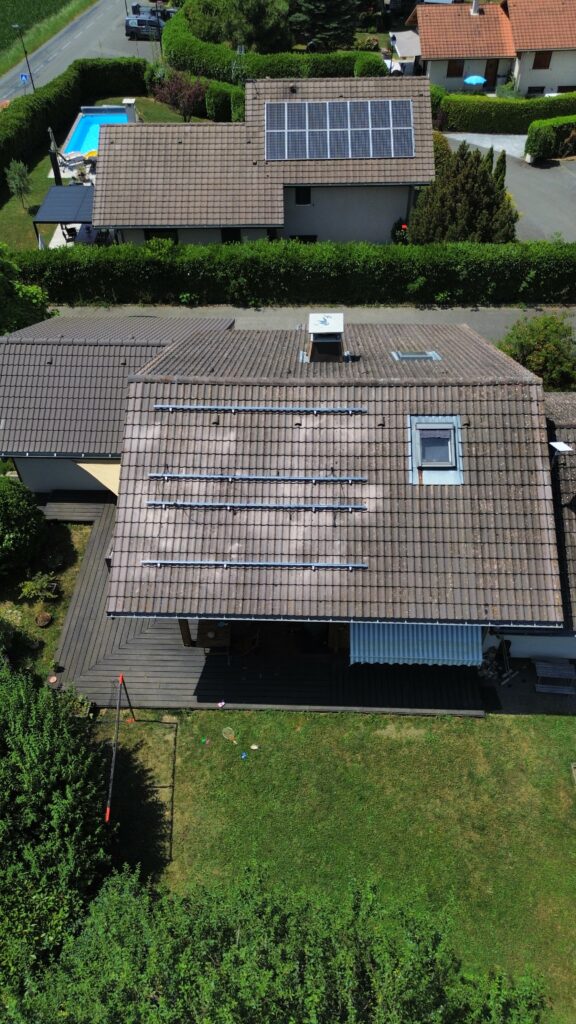 Toit d’une maison à Perrignier préparé pour l’installation de panneaux solaires, avec rails de fixation visibles.