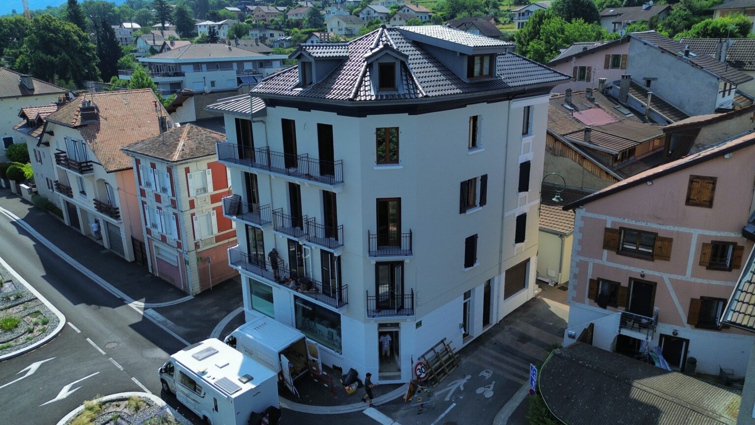 Immeuble rénové à Évian vu du ciel avec façade claire et menuiseries foncées