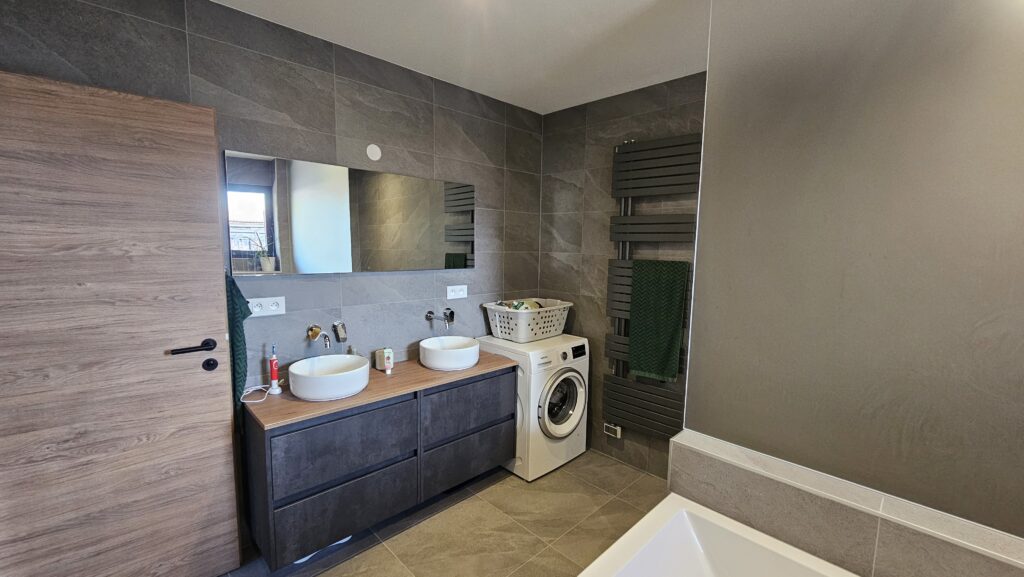 Meuble vasque avec machine à laver intégrée dans une salle de bains moderne à Douvaine.