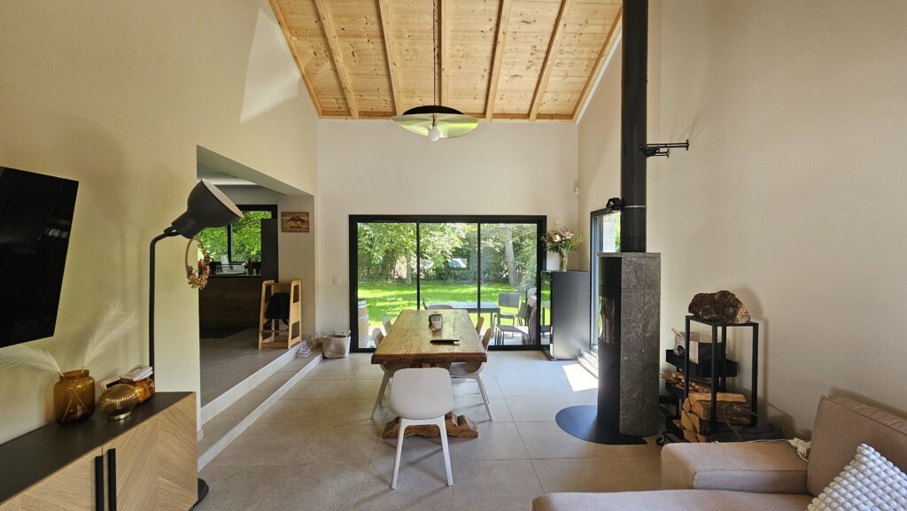 Pièce de vie ouverte et lumineuse avec coin repas et accès direct à la terrasse à Douvaine.