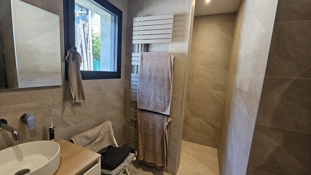 Salle de bains double vasque avec meuble bois clair et grande glace murale à Douvaine.