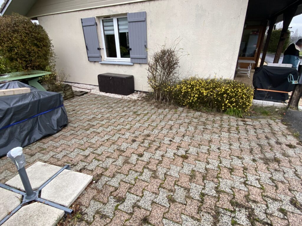 Ancienne terrasse avec dalles béton abîmées devant une maison à Bons-en-Chablais.