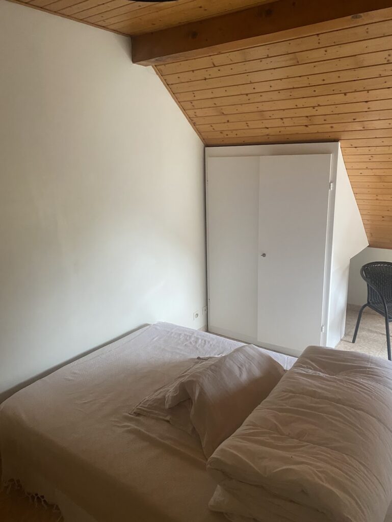 Chambre sous les combles avant rénovation à Bons-en-Chablais, avec lambris bois et placard intégré.