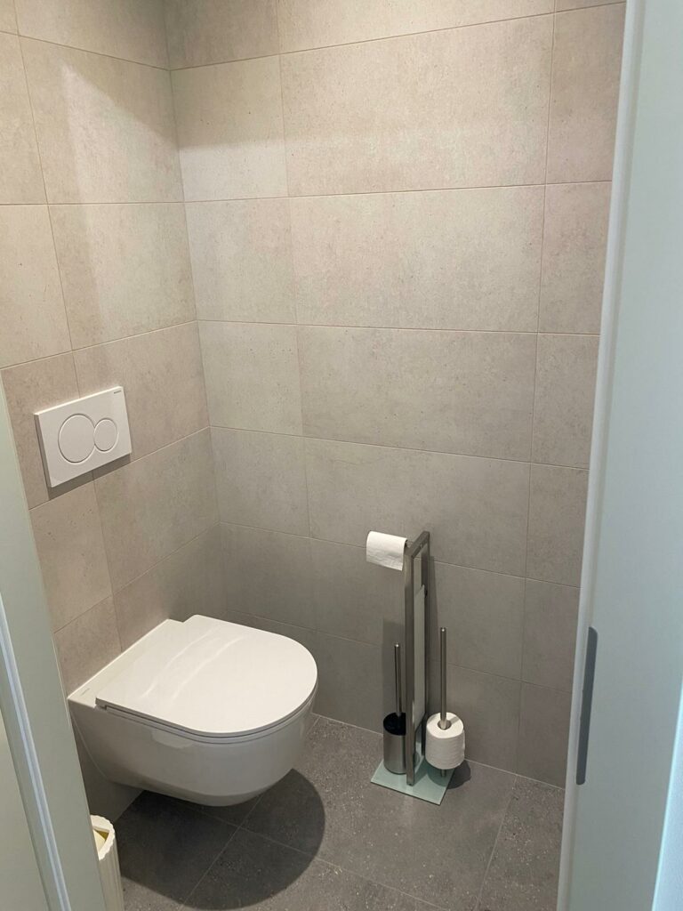 WC suspendu moderne avec carrelage gris au mur et au sol