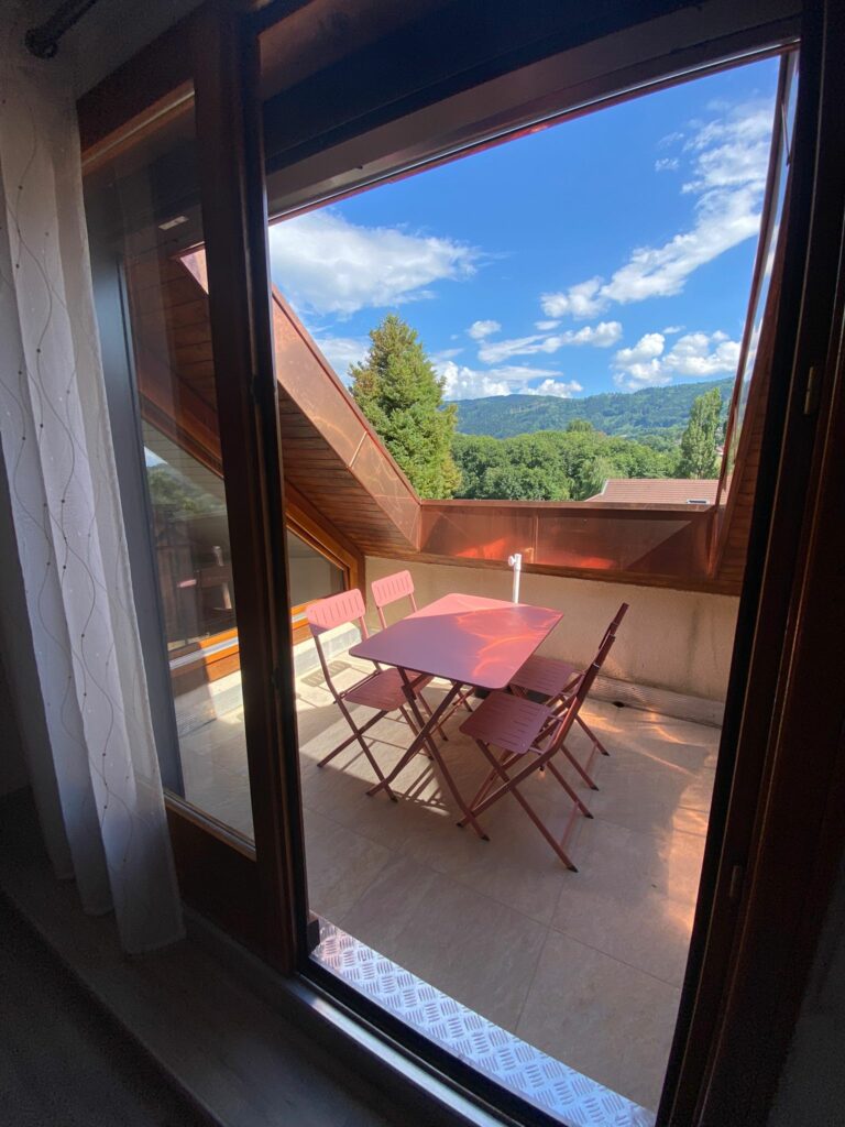 Terrasse attenante au salon avec table et chaises, vue sur les montagnes à Bons-en-Chablais