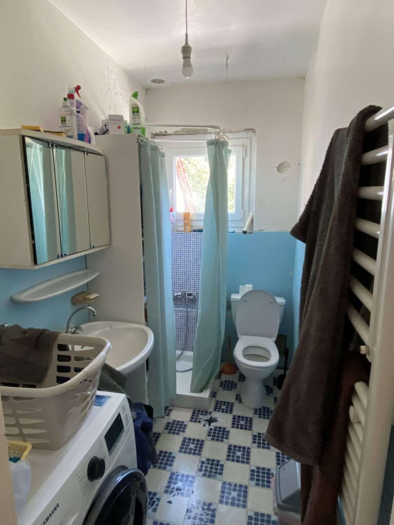 ancienne salle de bains à Annemasse avant rénovation avec carrelage bleu et sanitaires datés